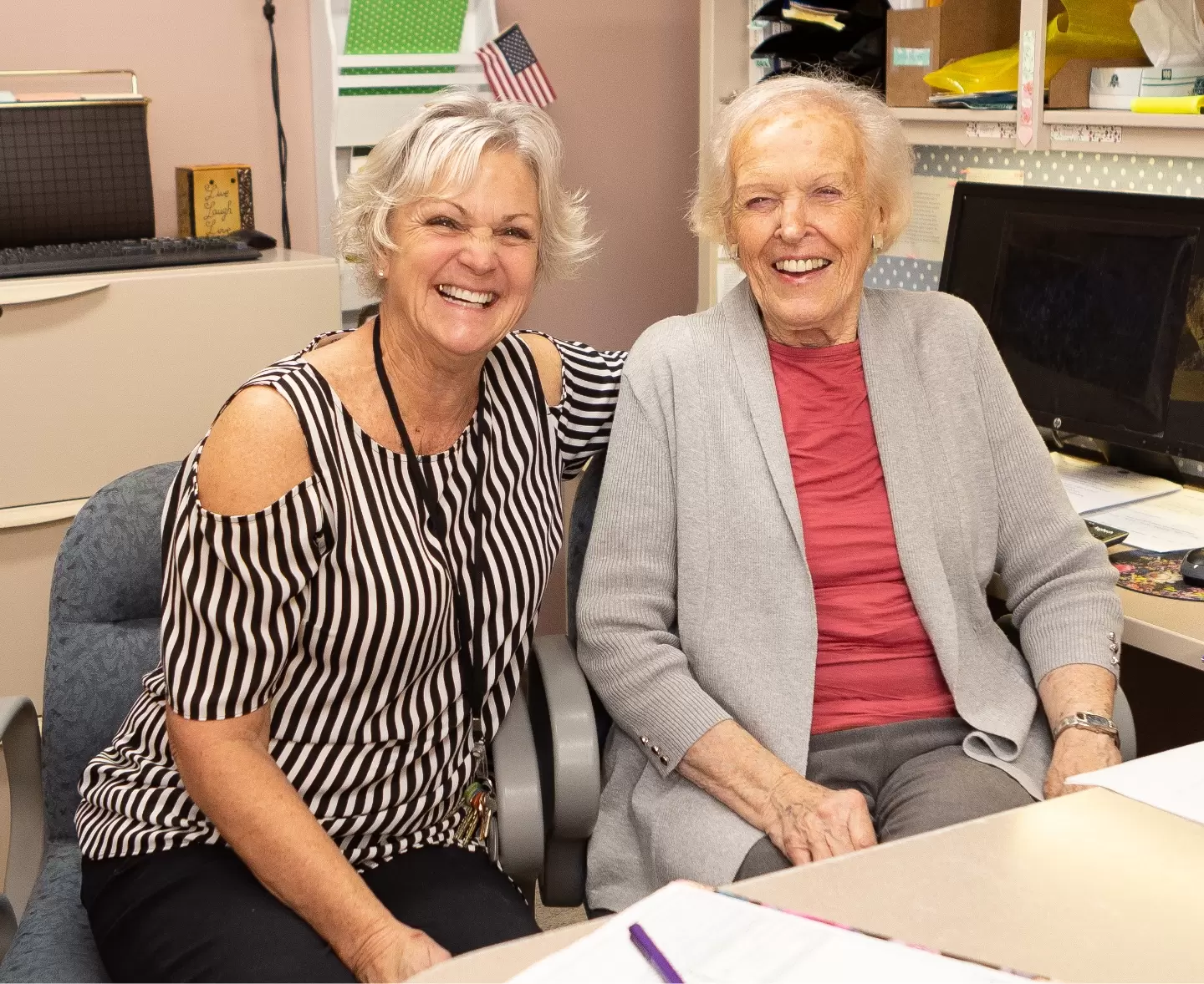 Office staff laughing with an elderly lady