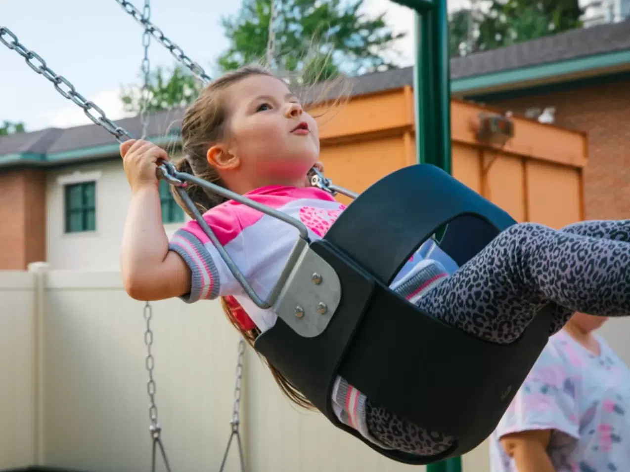 Girl in pink shirt swinging