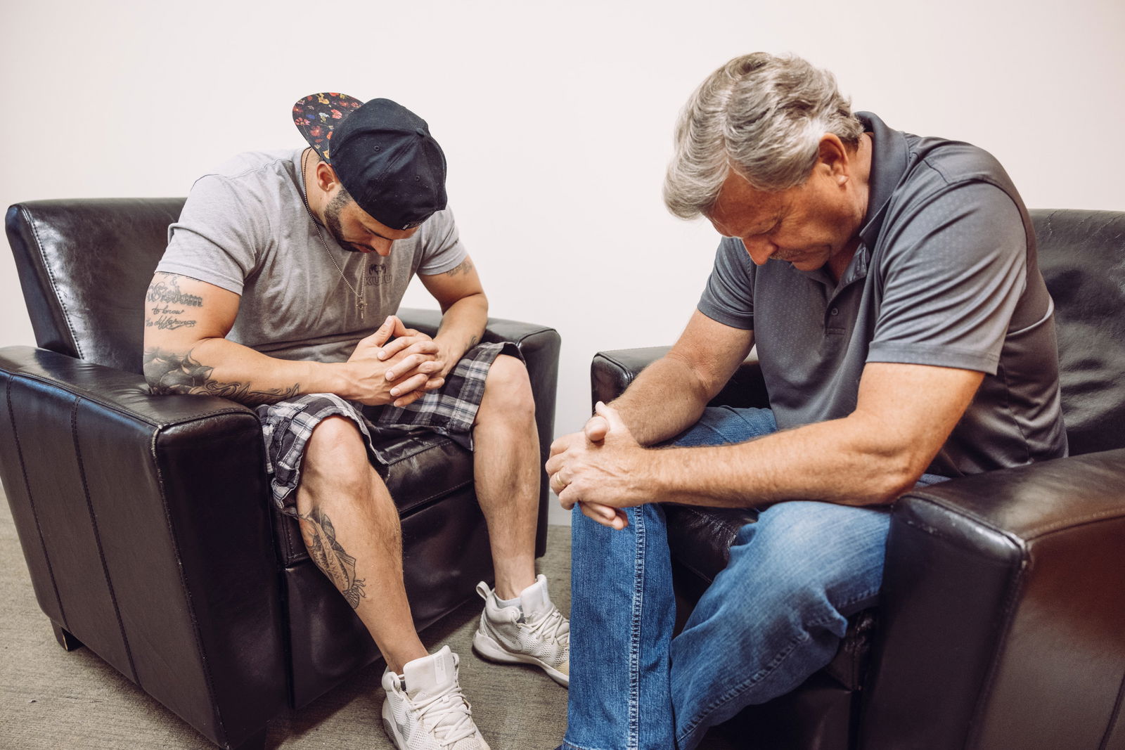 Two men sitting and praying together