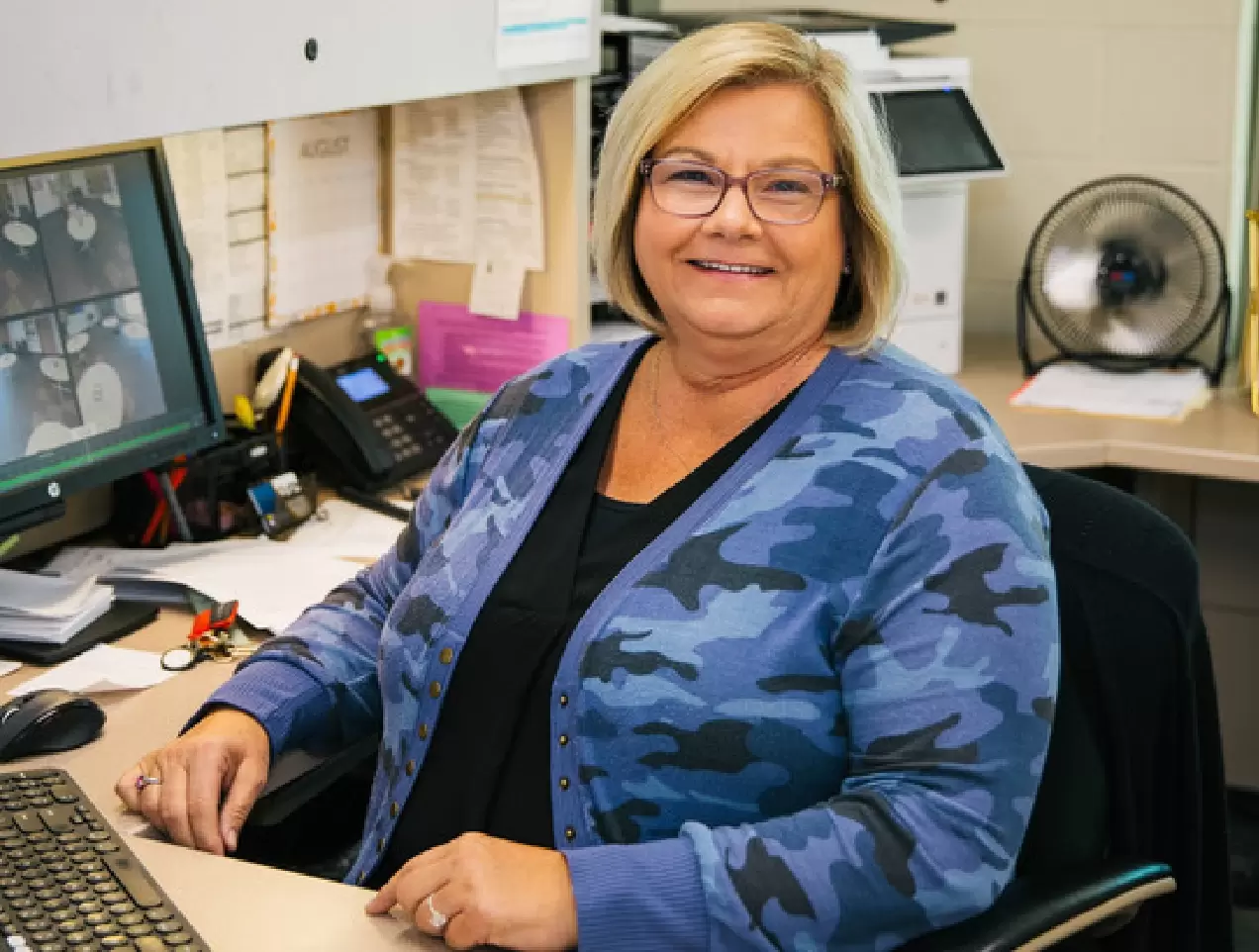 woman smiling and sitting at a desk