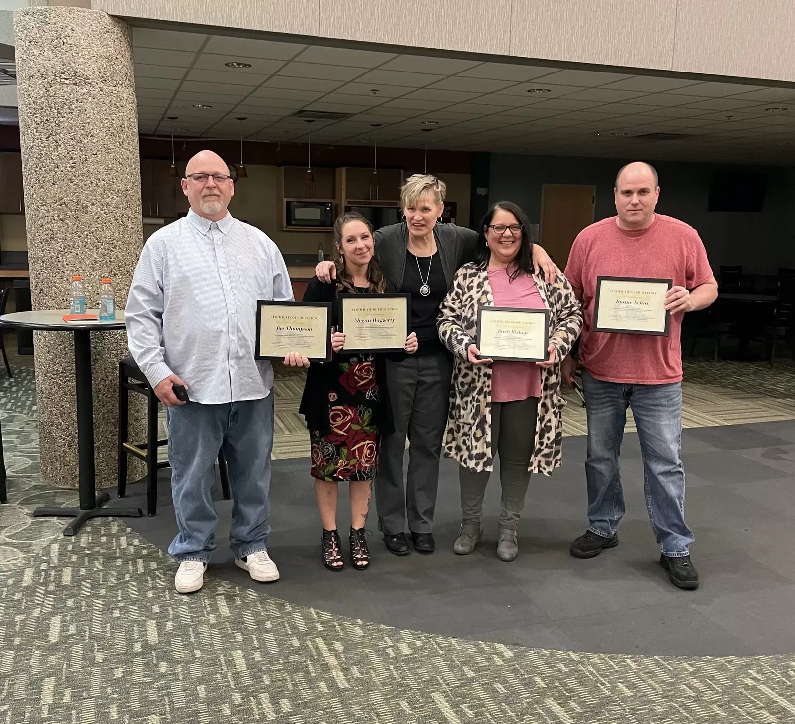 People smiling and holding certificates of completion