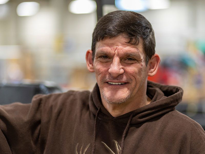 Man with brown hair wearing a brown hoodie