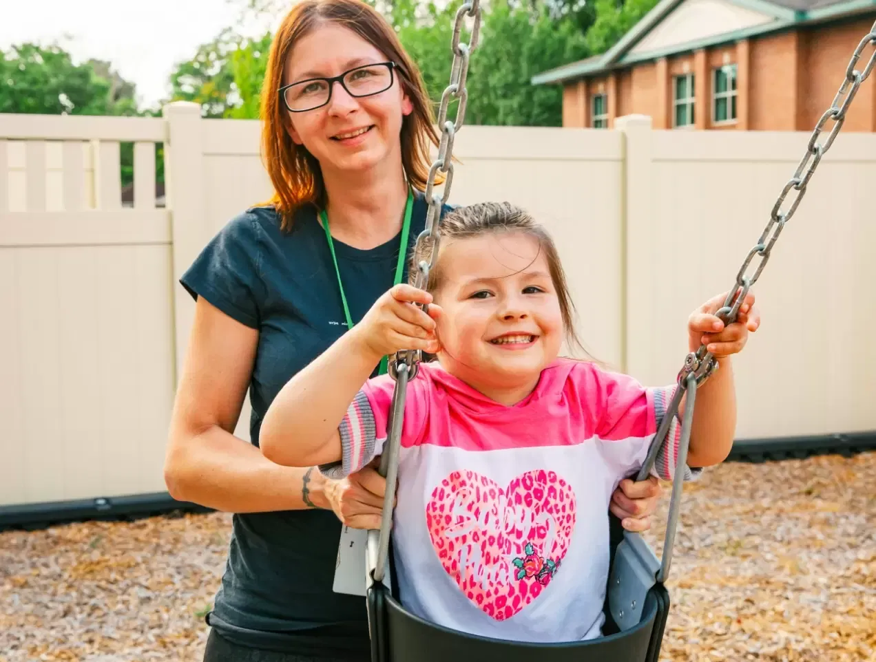 Woman pushing a girl in a swing