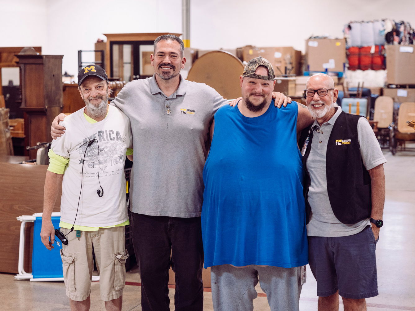 Group of men posing for a picture in a warehouse